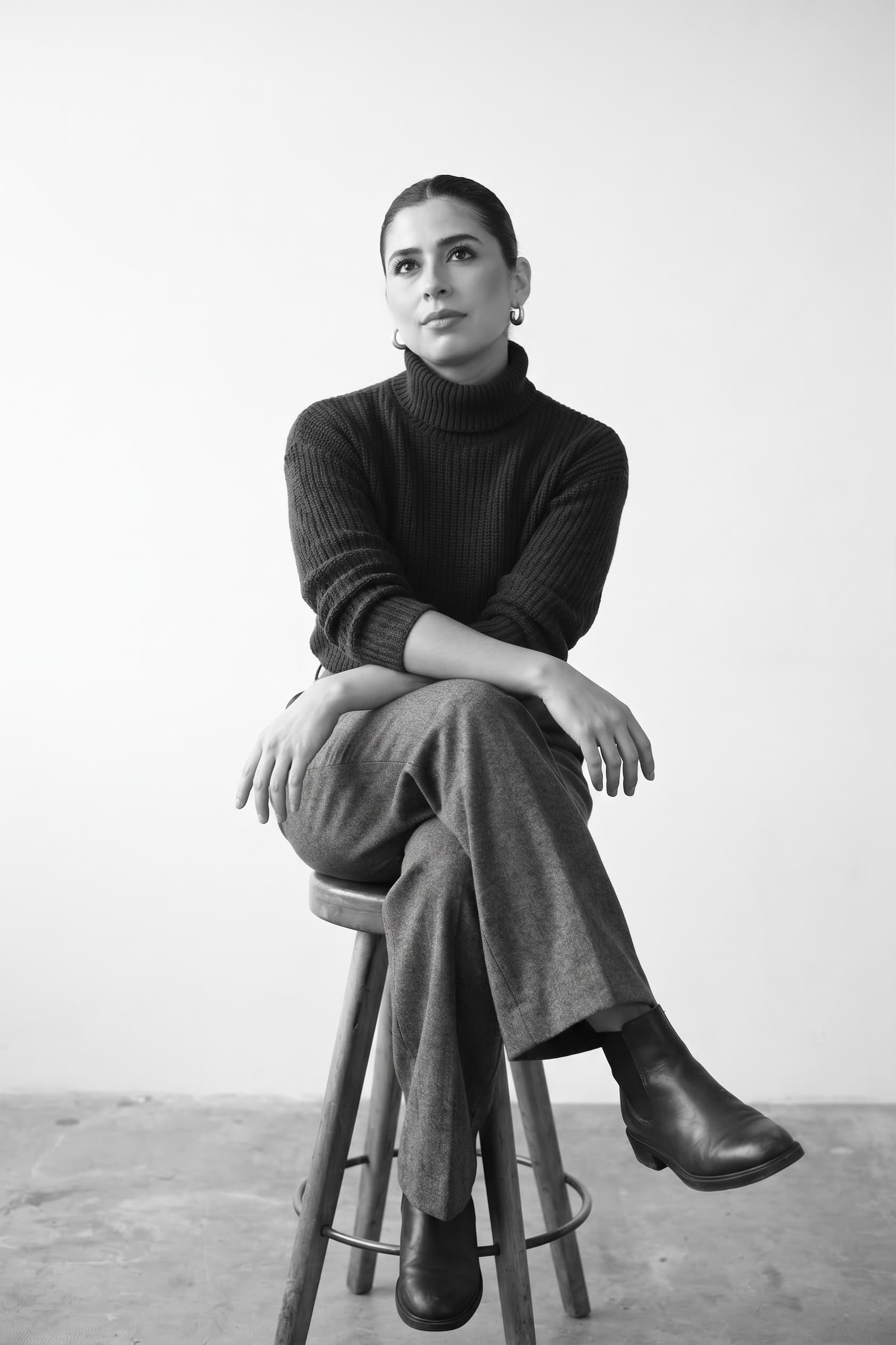 Retrato en blanco y negro de Sianlly, especialista en mercadeo y redes sociales de Biianchi Estudio en Costa Rica, sentada sobre un banco de madera
